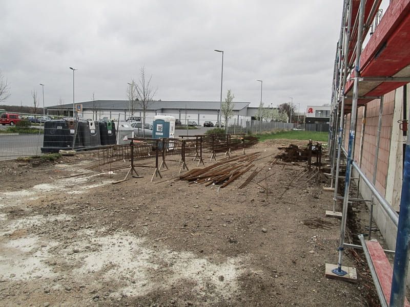 Eine Baustelle mit Gerüst und einem Gebäude im Hintergrund.