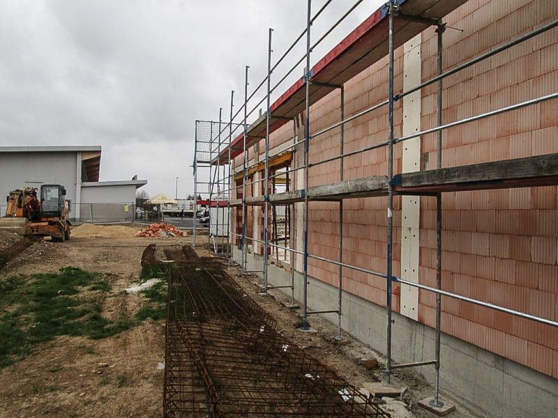 Ein im Bau befindliches Gebäude mit einem Gerüst an der Seite.