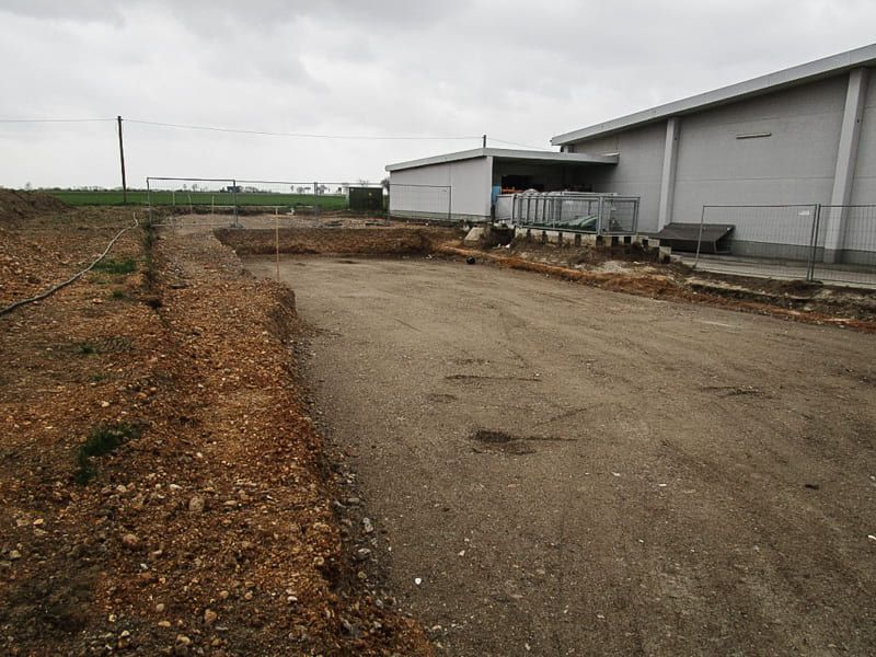 Eine unbefestigte Straße, die an einem bewölkten Tag zu einem weißen Gebäude führt