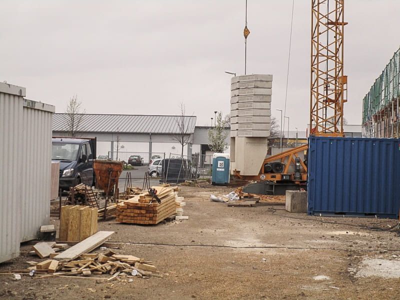 Eine Baustelle mit einem blauen Container im Vordergrund