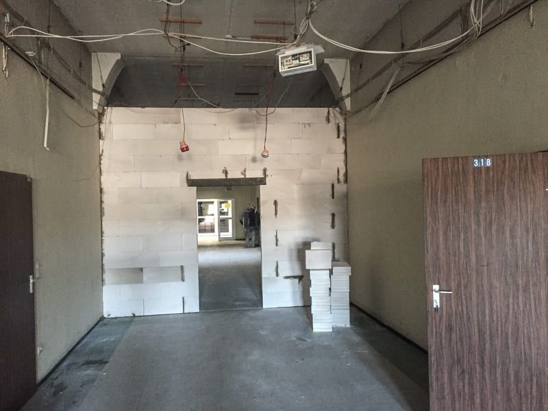 Ein leerer Raum mit einer Holztür und einer weißen Wand