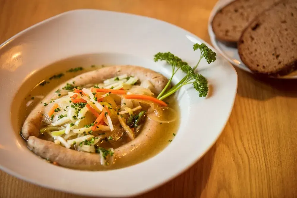 Ein Tisch mit einer Vase mit Blumen und Weingläsern darauf