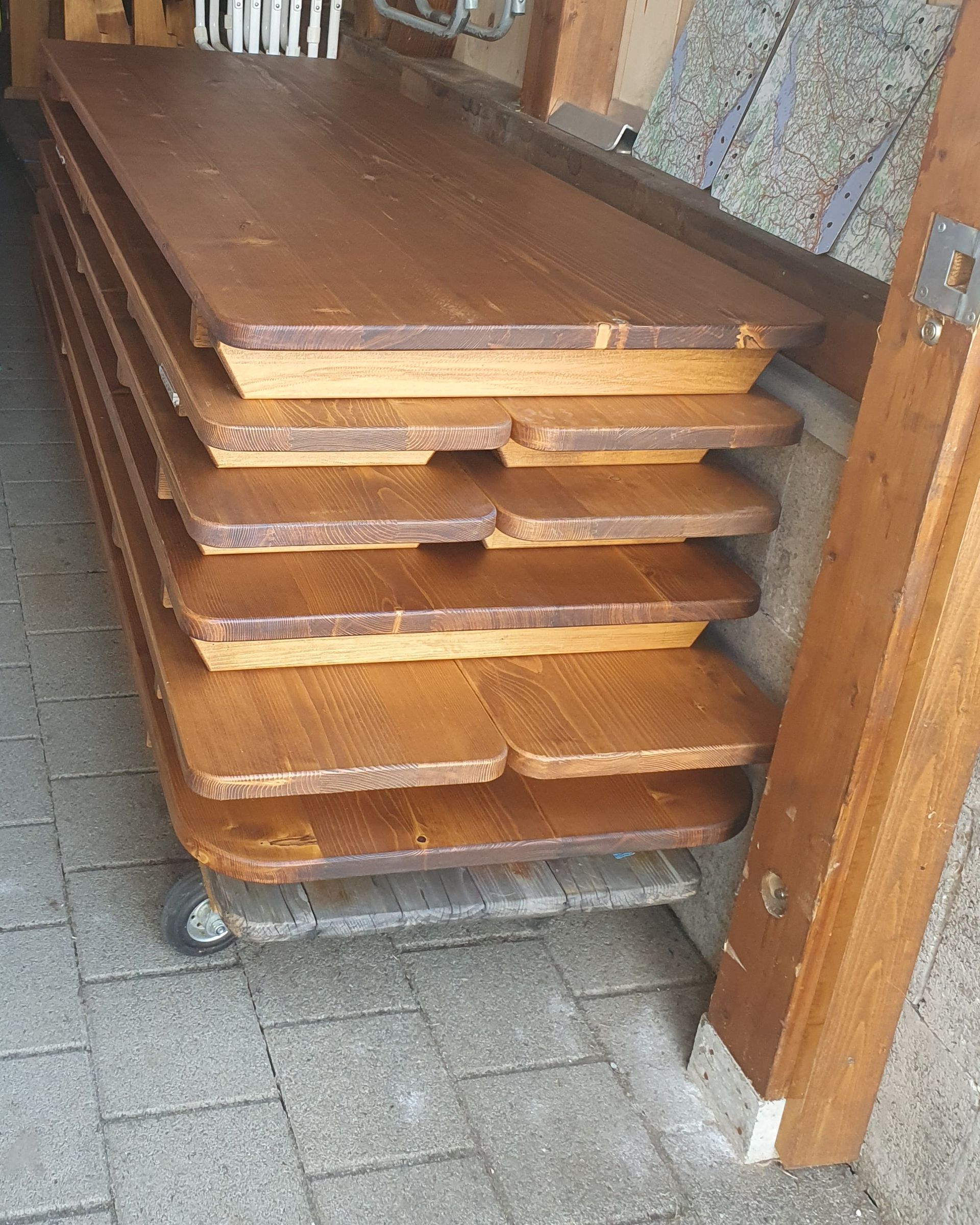 Aufgestapelte Holztischgarnituren.