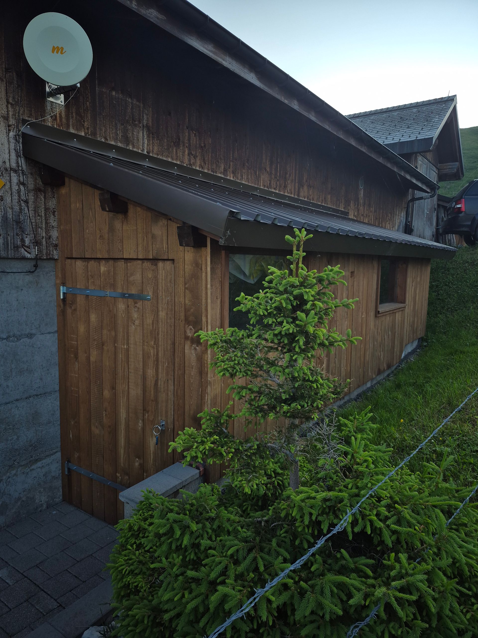 Person, die im Freien mit einer Bohrmaschine Holzbretter auf einem Terrassenrahmen befestigt.