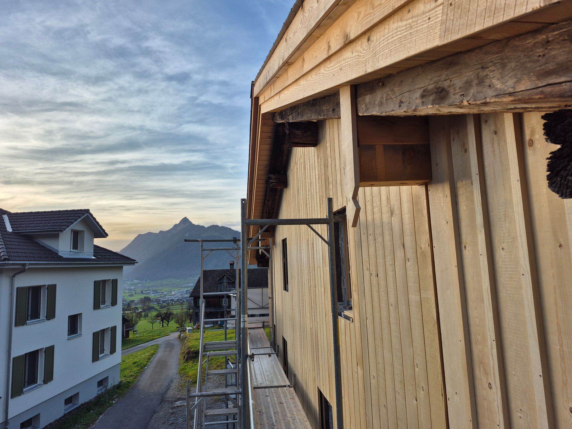 Person schleift in einem Haus eine hölzerne Treppenstufe mit Schleifpapier.