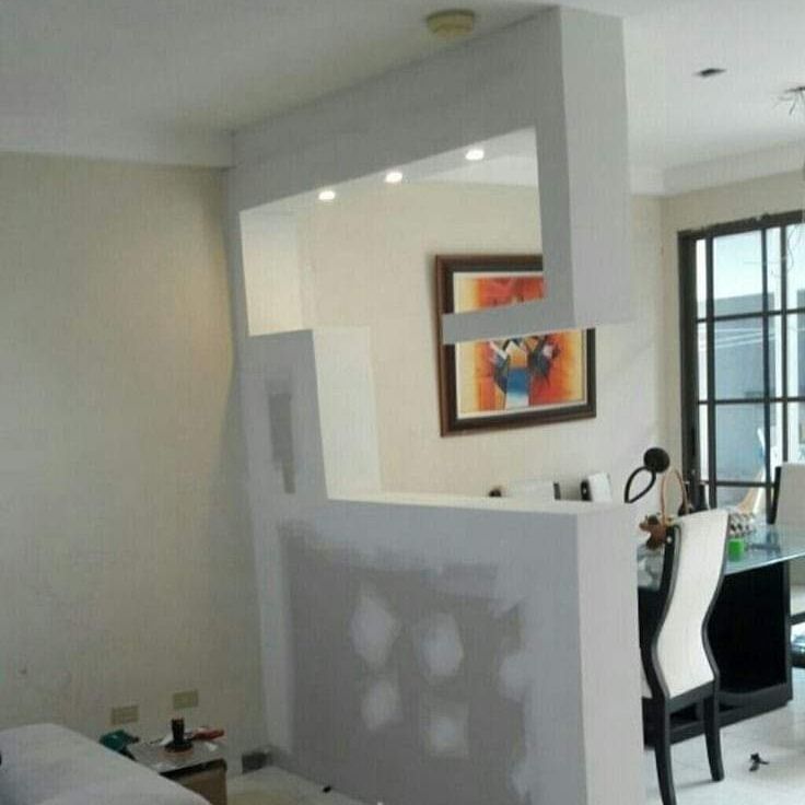 Una habitación con un sofá y sillas y un cuadro en la pared.