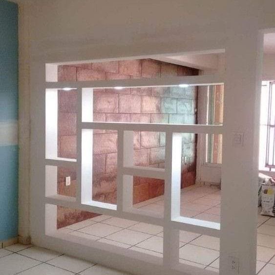 Un separador de ambientes en una habitación con una pared de ladrillos detrás.