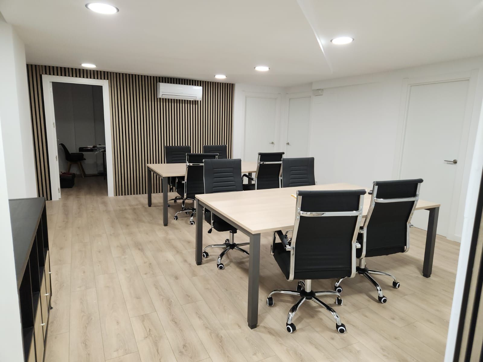 Una fila de camisas azules están colgadas en una tienda de ropa.