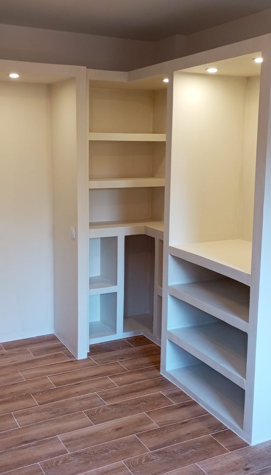 Un armario con muchos estantes y percheros.