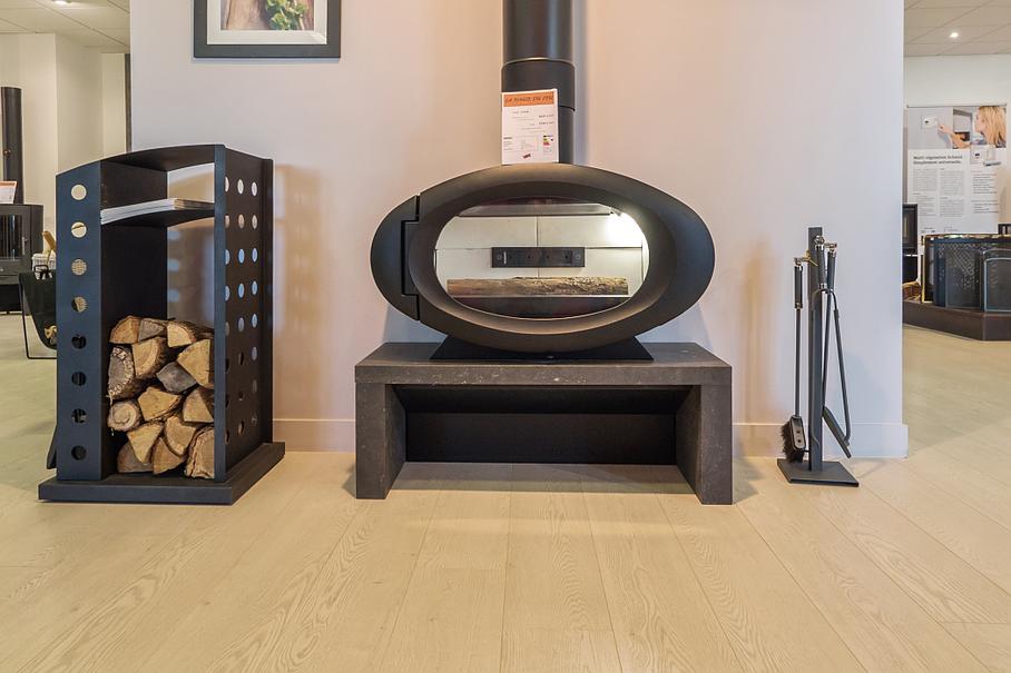 Cheminée ovale sur socle en pierre, avec rangement du bois