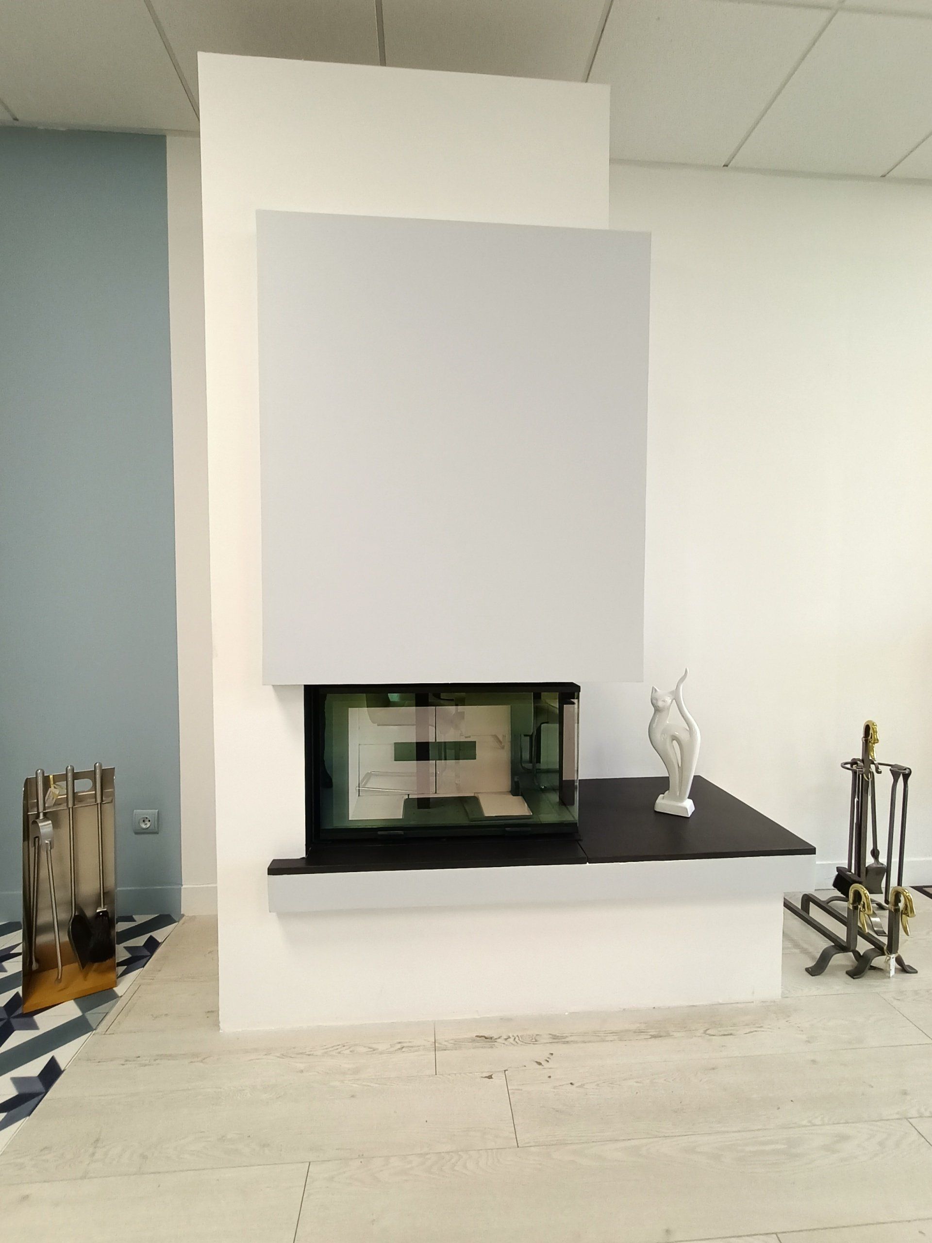 Cheminée moderne avec foyer noir, contour blanc et objets décoratifs