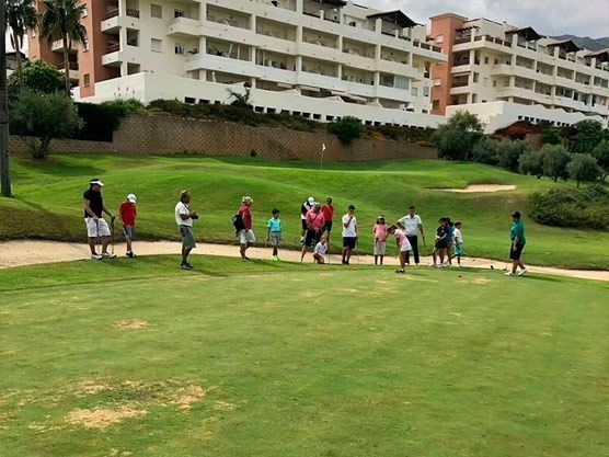 Un grupo de personas camina por un campo de golf.