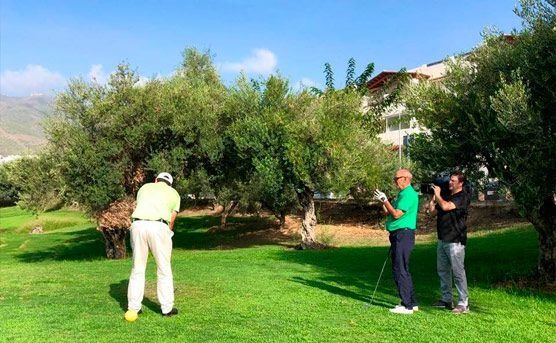 Un grupo de hombres está jugando al golf en un exuberante campo verde.
