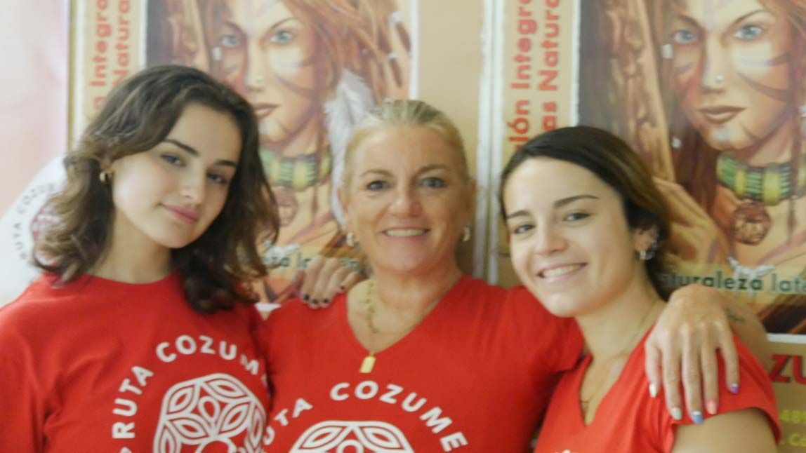 Tres mujeres con camisetas rojas que dicen Ruta Cozumel