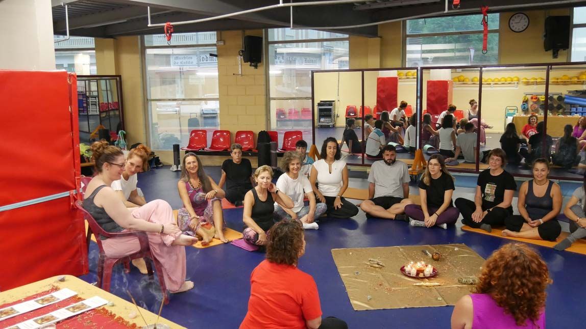Un grupo de personas está sentado en el suelo en un gimnasio.