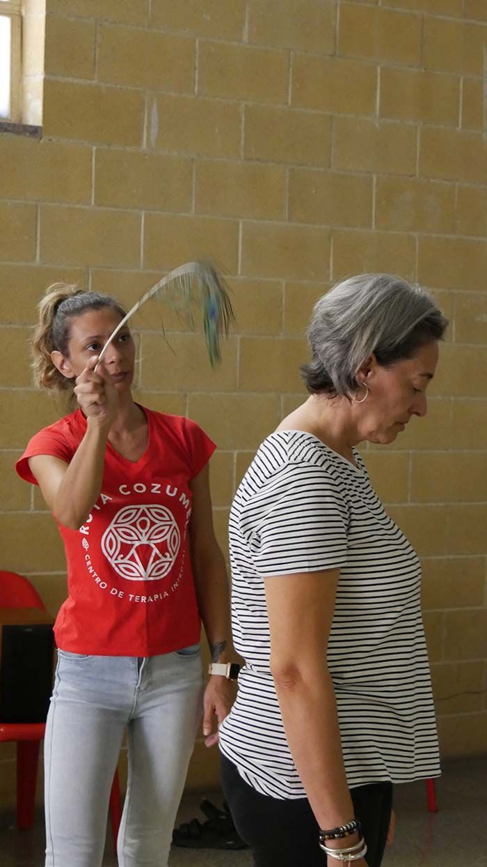 Una mujer con una camisa roja con un círculo está parada junto a otra mujer.