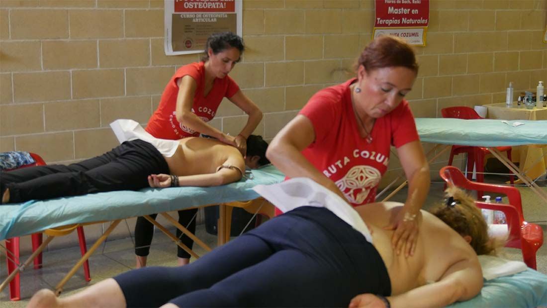 Una mujer con una camiseta roja de Costa Costa le está dando un masaje a otra mujer.