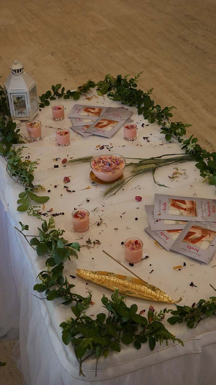 Una mesa con velas y hojas sobre ella.