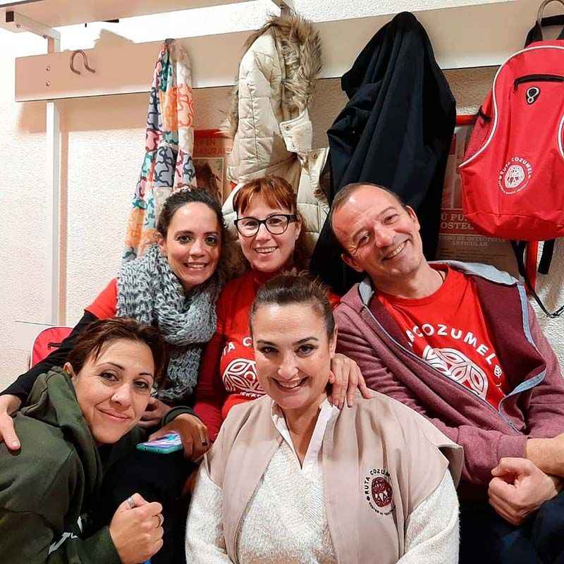 Un grupo de personas posando para una foto con un hombre que lleva una camiseta roja que dice "ozumers".