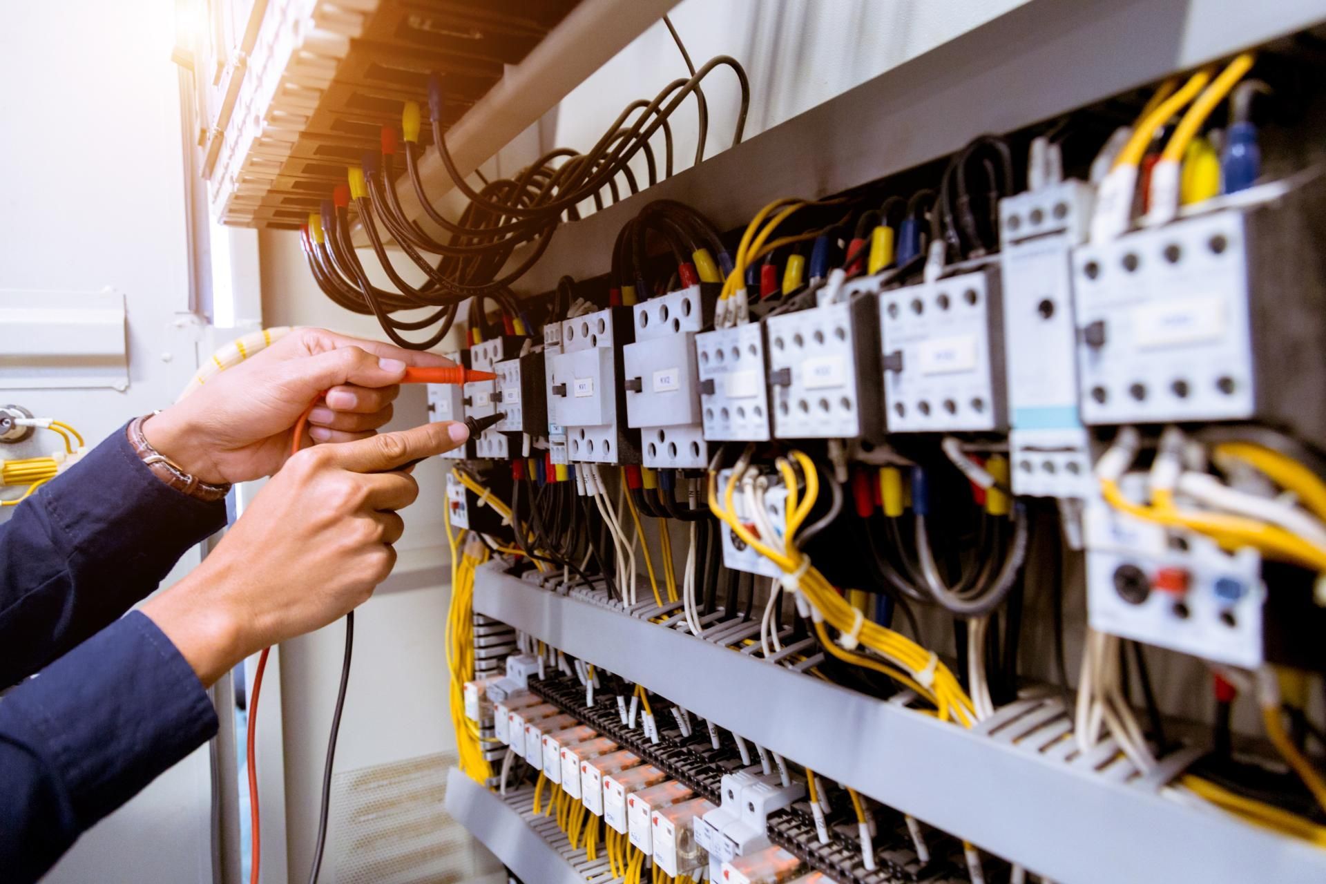 Ein Elektriker arbeitet mit einem Schraubenzieher an einer Schalttafel