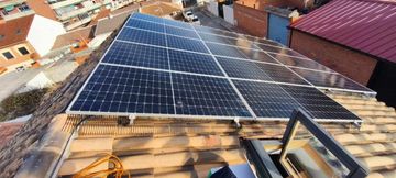 Instalación de paneles solares en construcción sobre un tejado de tejas, vista desde arriba.