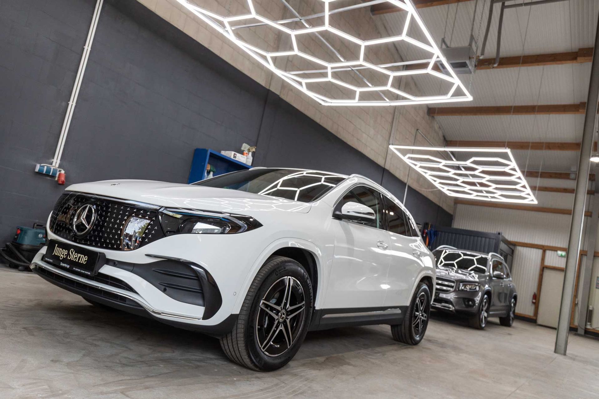 Ein weißer Mercedes-Benz EQE steht in einer Garage.