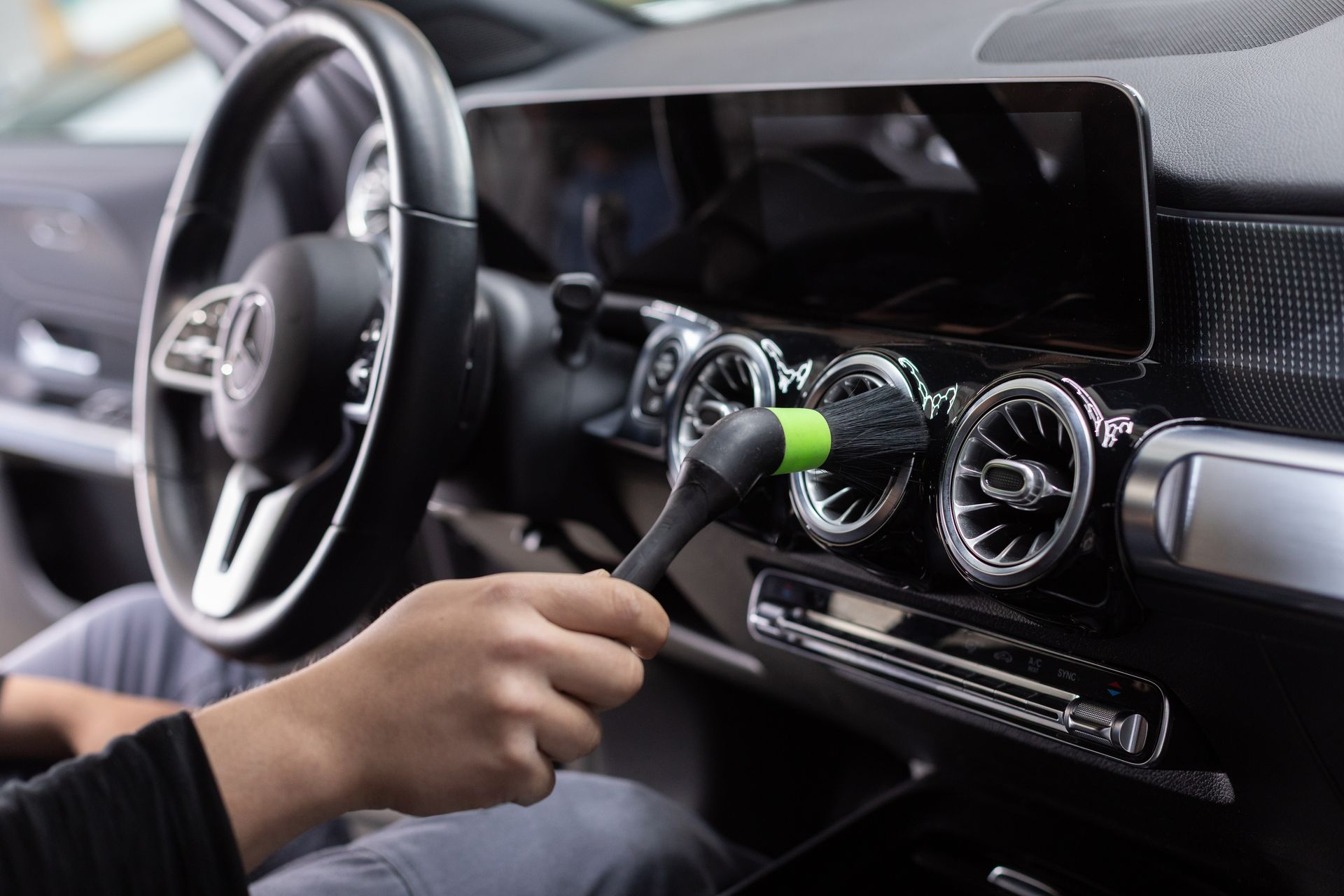 Der Innenraum eines Autos mit schwarzen Ledersitzen und einem Lenkrad.