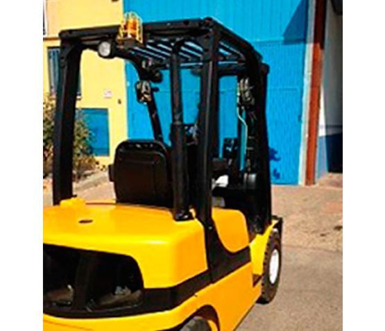 Una carretilla elevadora amarilla está estacionada frente a una puerta de garaje azul.