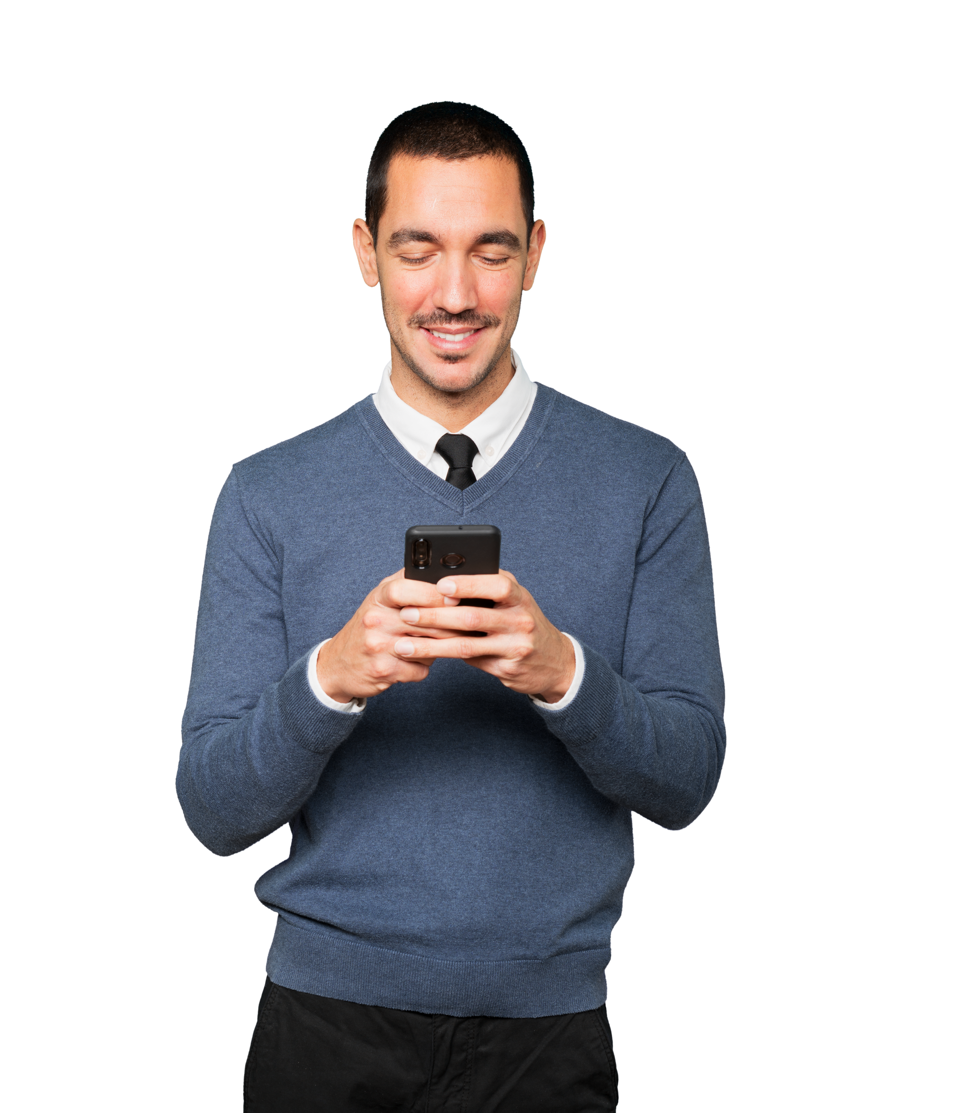 Une personne vêtue d'un pull bleu et d'une chemise blanche à col, regardant vers le bas et souriant tout en tenant un smartphone.