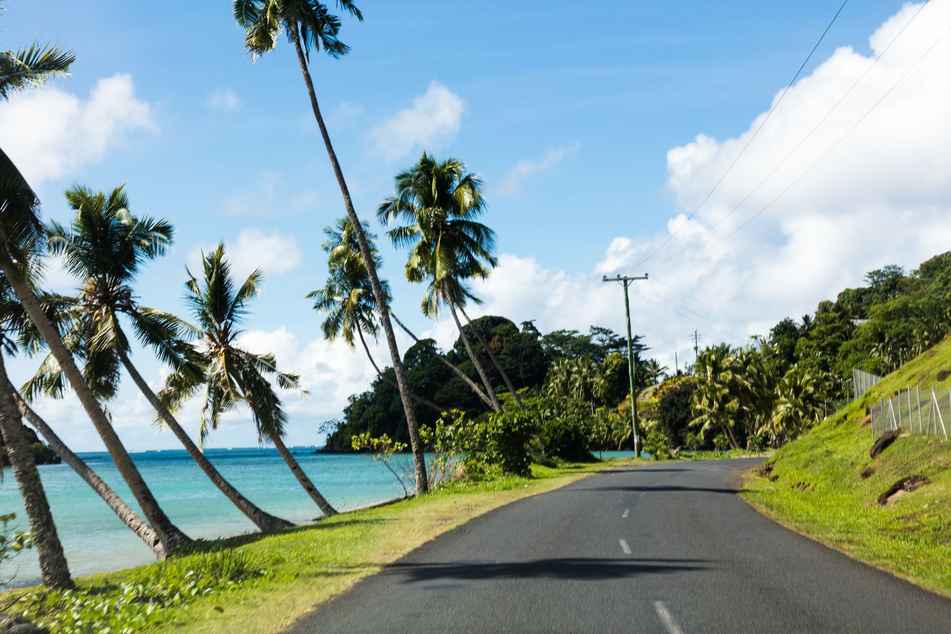 Route avec l'océan et les palmiers sur le côté
