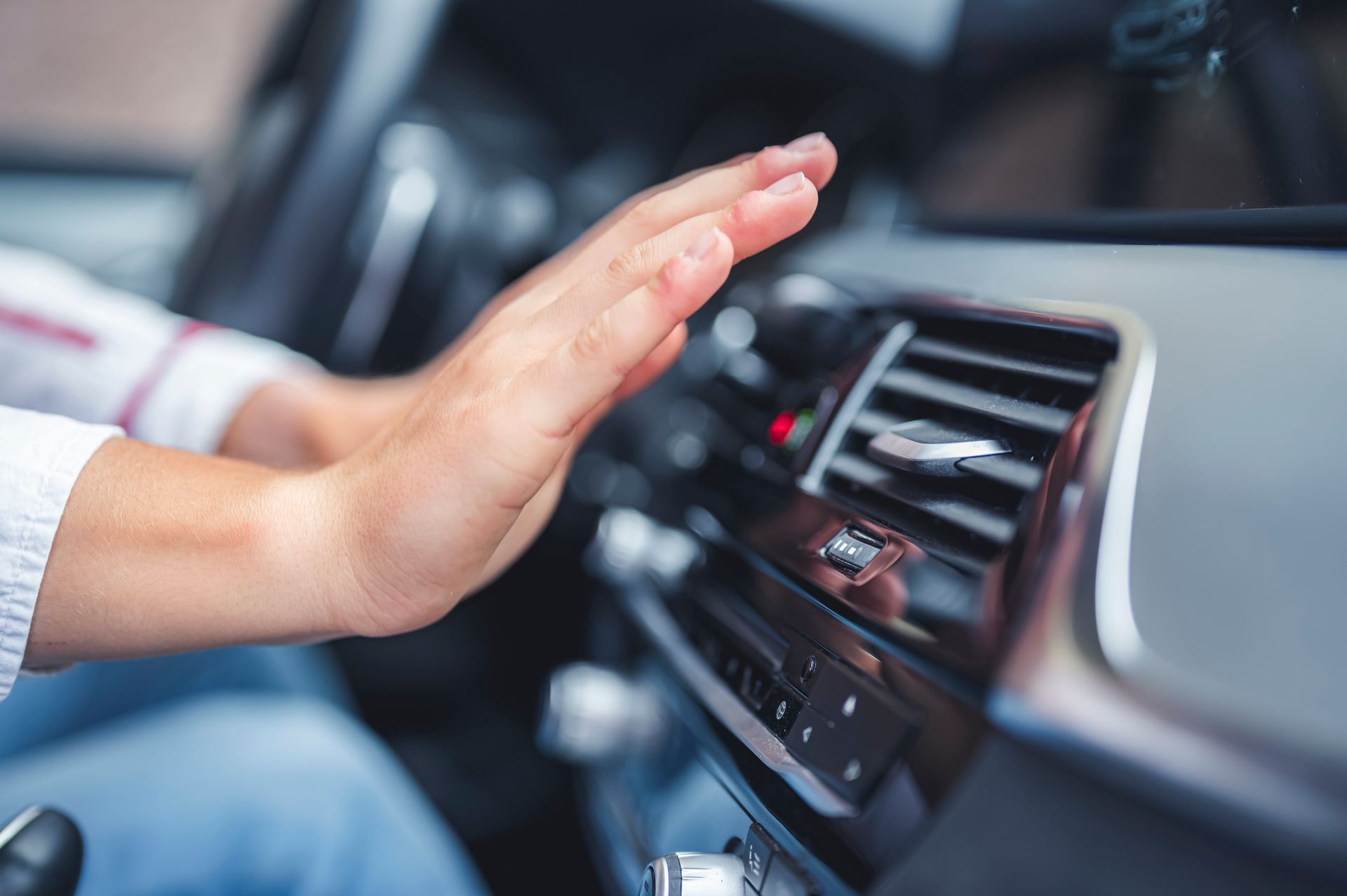Deux mains devant le souffle d'air de la climatisation de la voiture