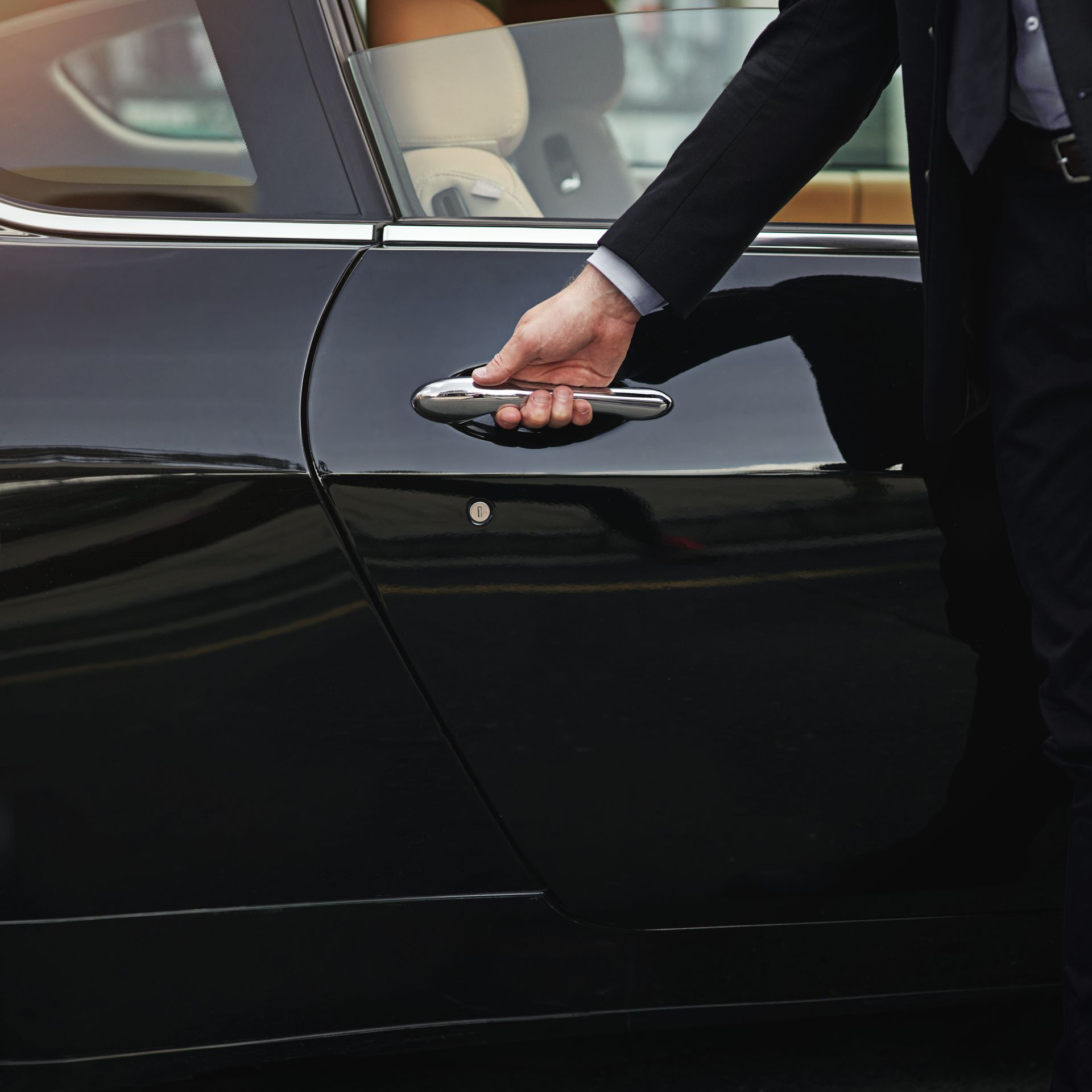 Main qui ouvre une portière de  voiture