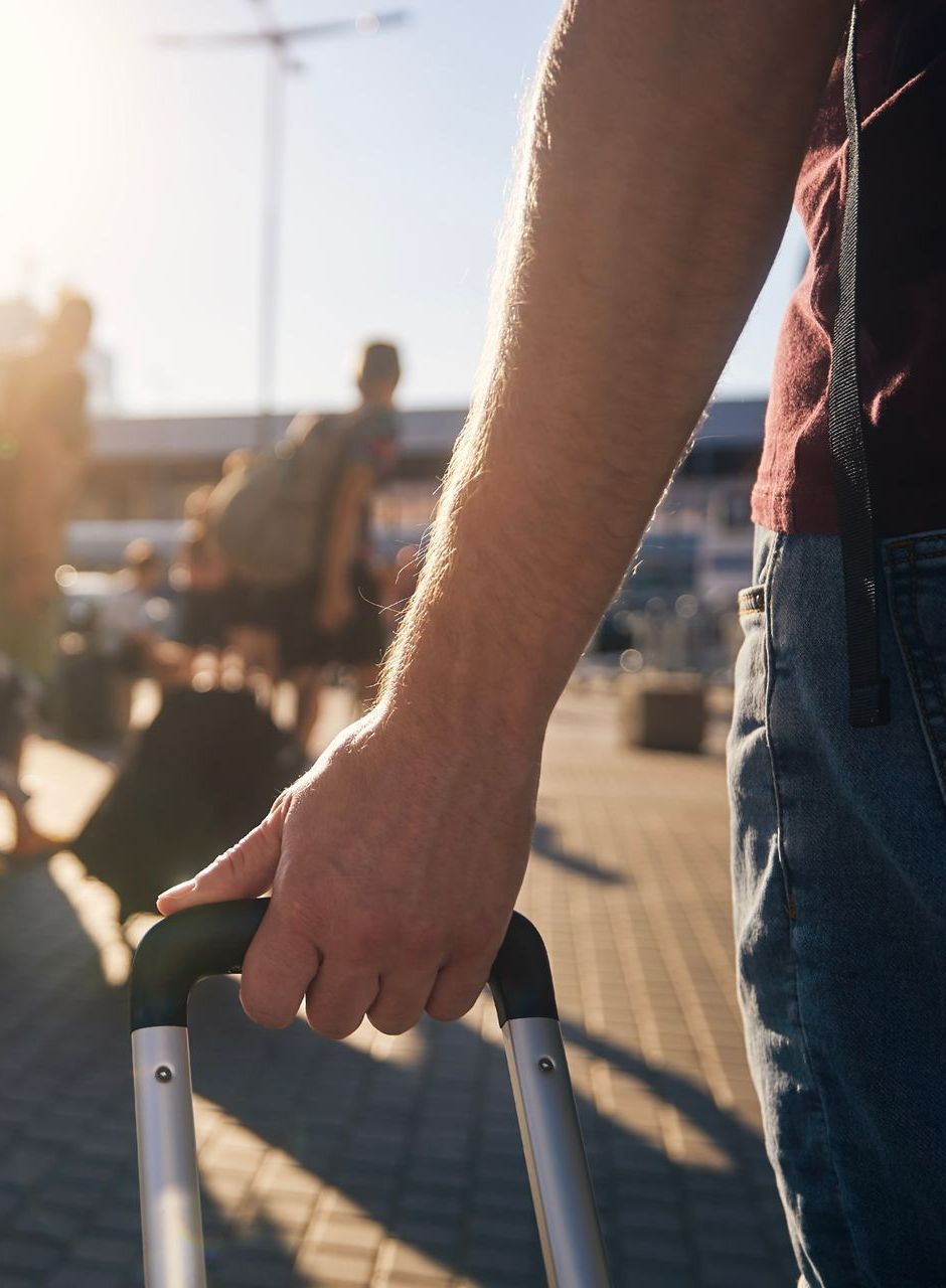 Main qui tient une valise à l'aéroport