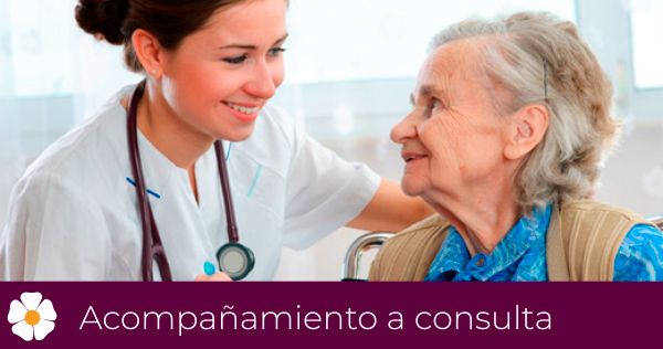 Una enfermera está hablando con una mujer mayor en silla de ruedas.
