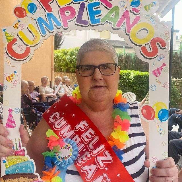Una mujer sostiene un cartel que dice cumpleanos