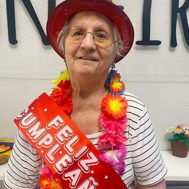 Una mujer que lleva una faja roja que dice feliz cumpleaños