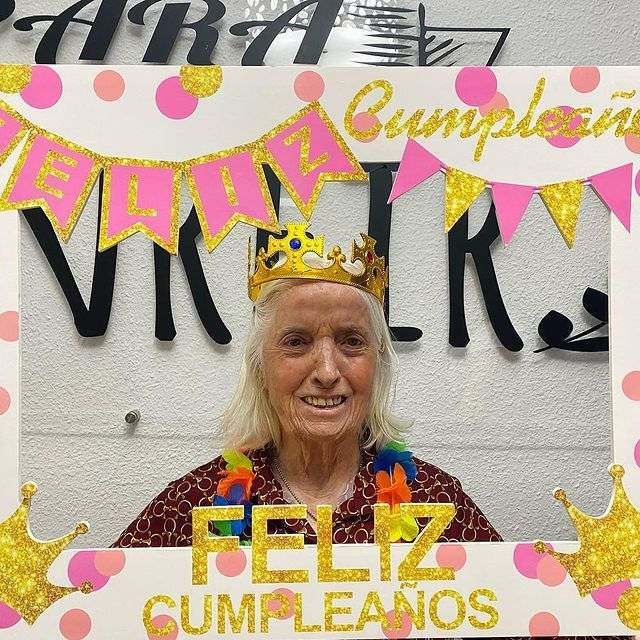 Una mujer que lleva una corona está en un marco que dice feliz cumpleaños