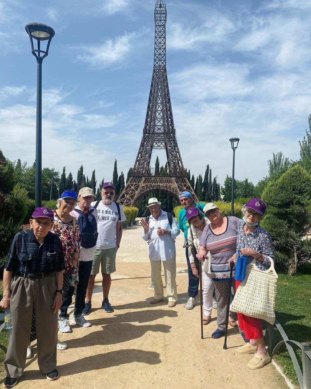 Un grupo de personas está de pie frente a la Torre Eiffel.