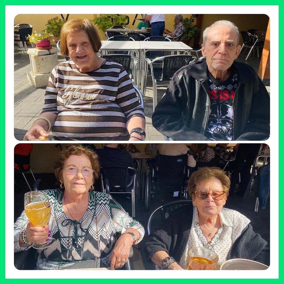 Un hombre y una mujer están sentados en una mesa sosteniendo vasos de cerveza.