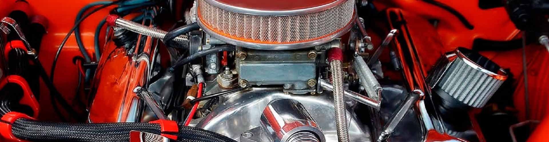 Un primer plano de un motor de automóvil rojo con un filtro de aire.
