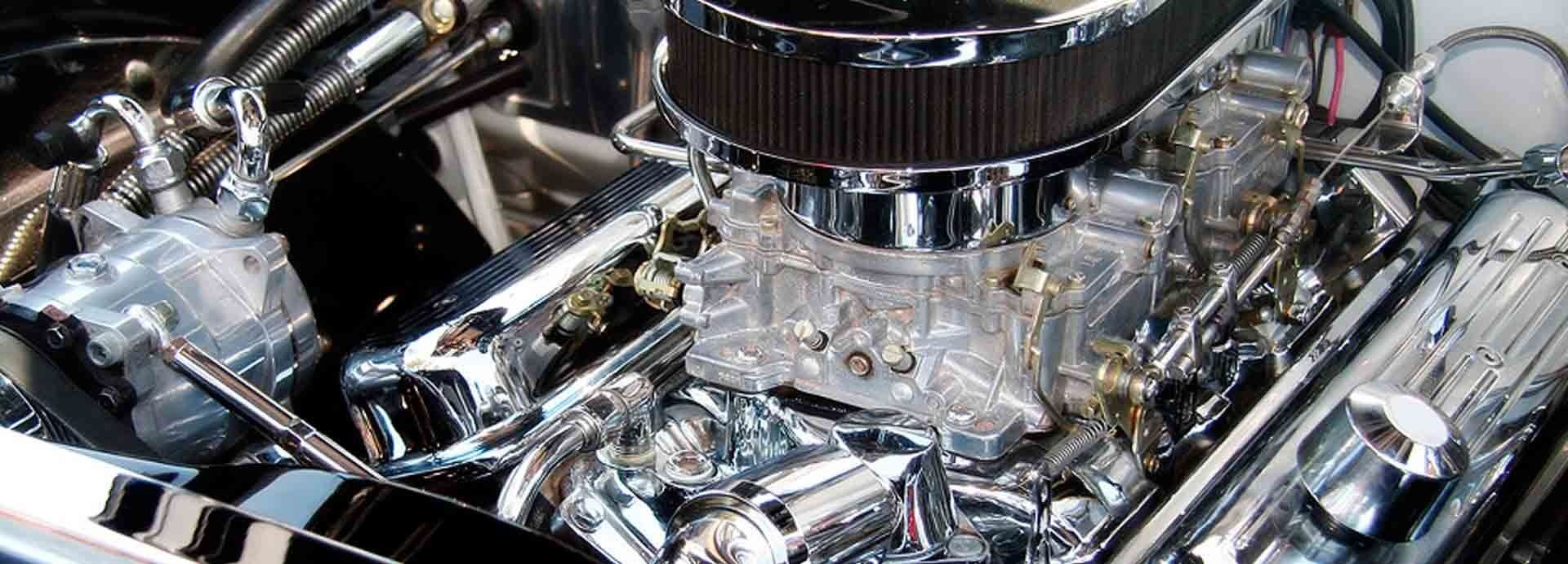 Un primer plano de un motor cromado con un filtro de aire negro.