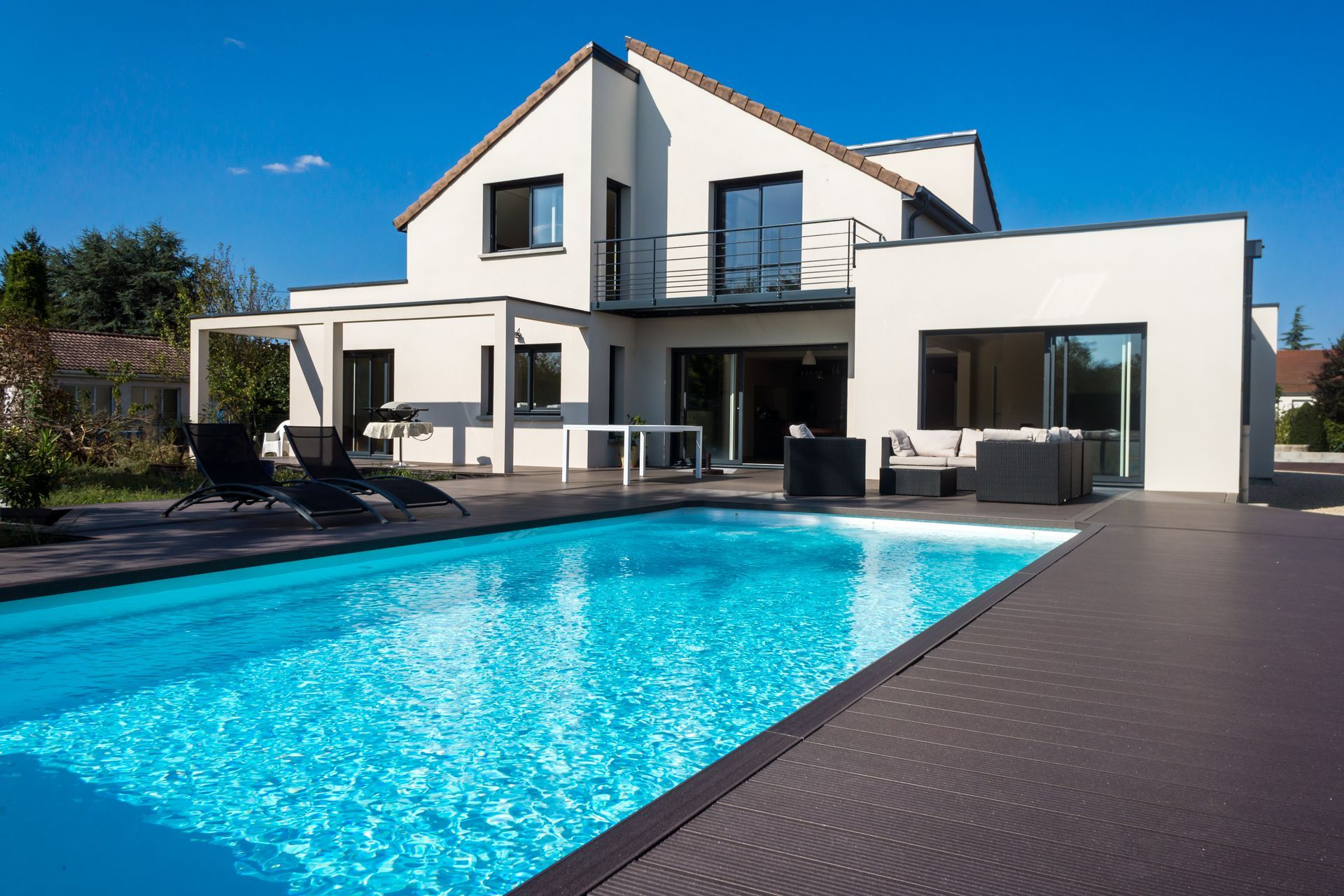Une maison moderne avec une piscine en premier plan.