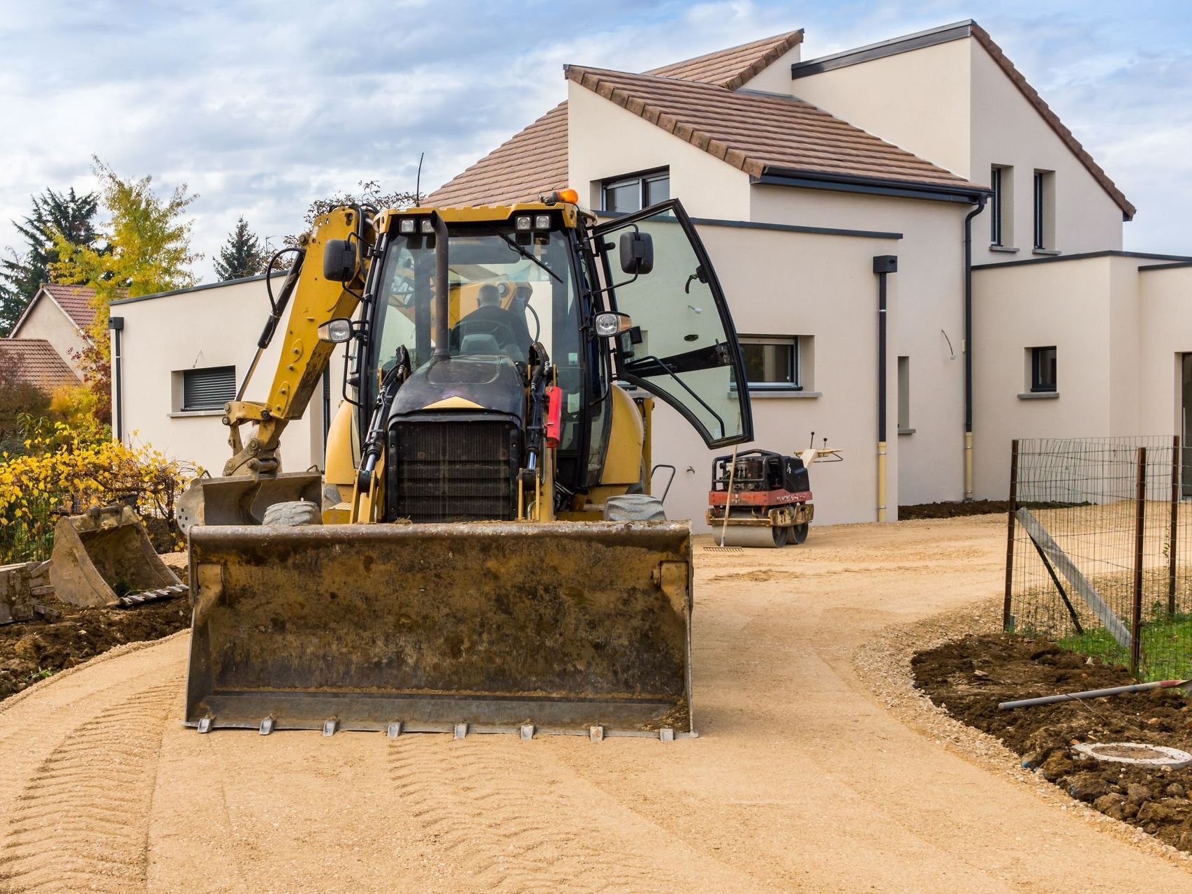 Un engin de chantier sur l'allée d'une maison.