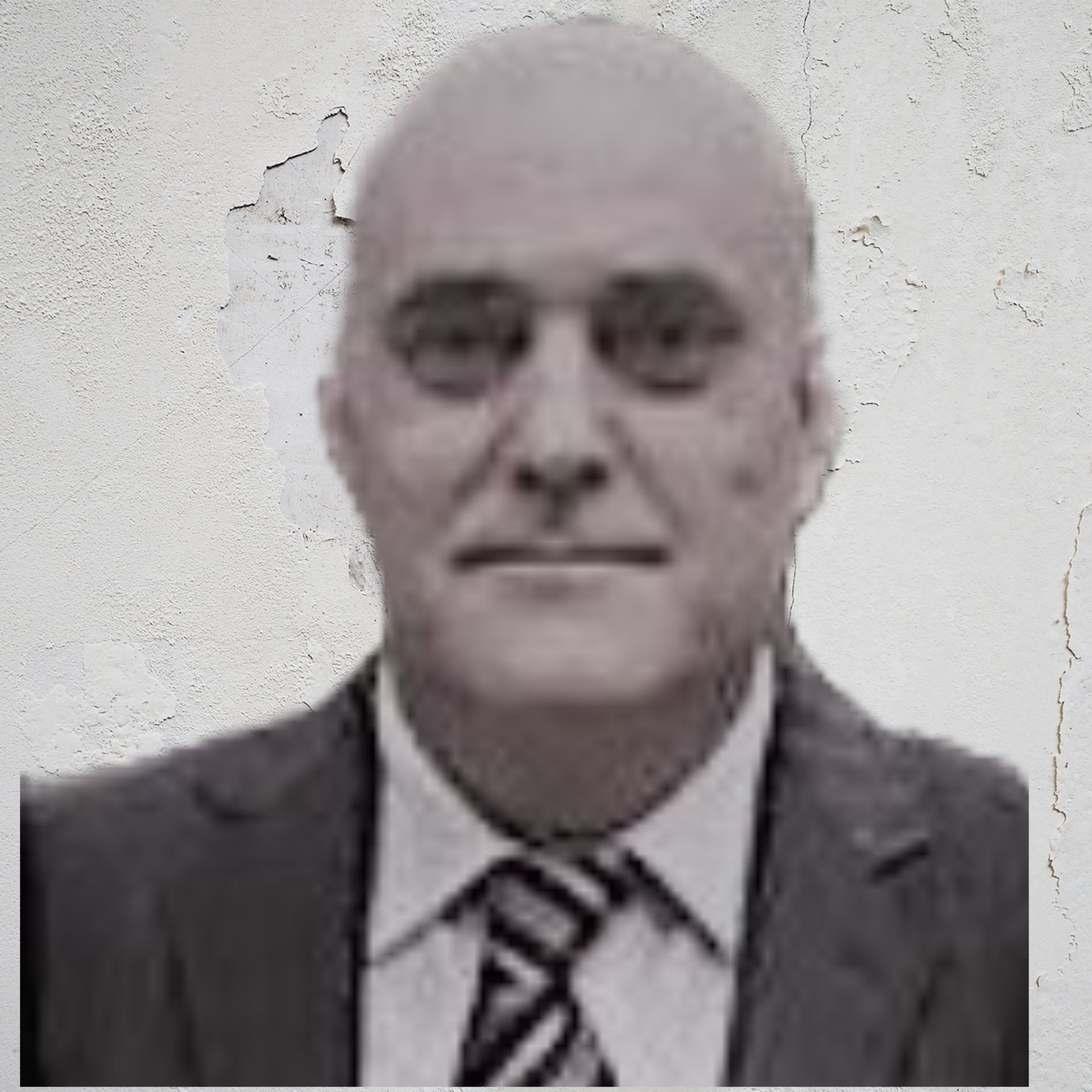 Un hombre calvo con traje y corbata mira a la cámara.