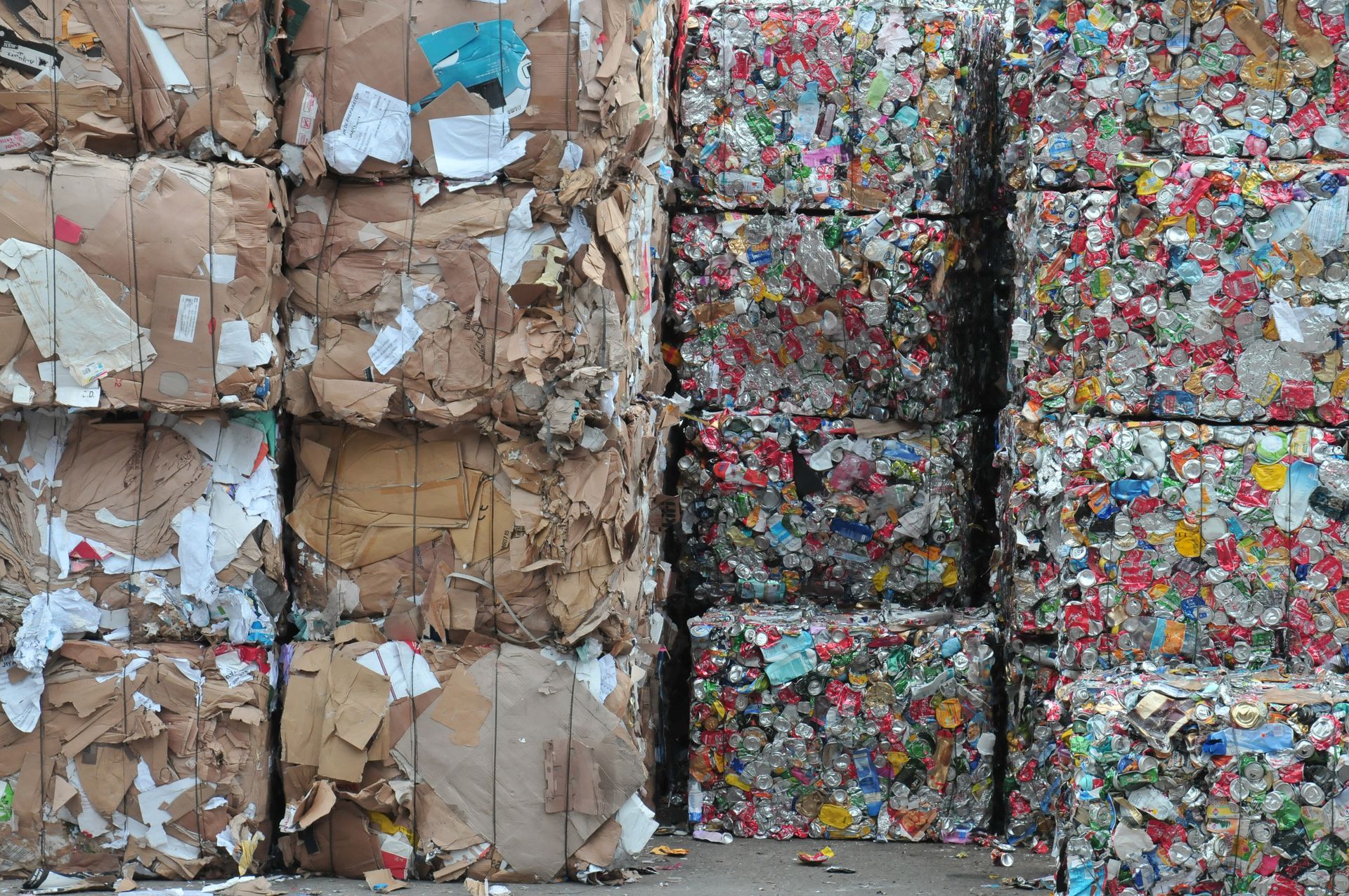Des piles de carton compressé et de vieux papiers colorés dans un centre de recyclage.