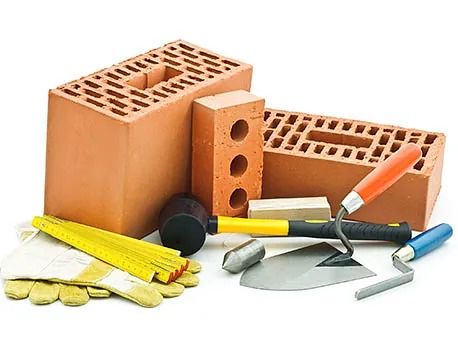 Maons, paletes, martell, eines de mesura i guants de treball, materials de construcció sobre un fons blanc.