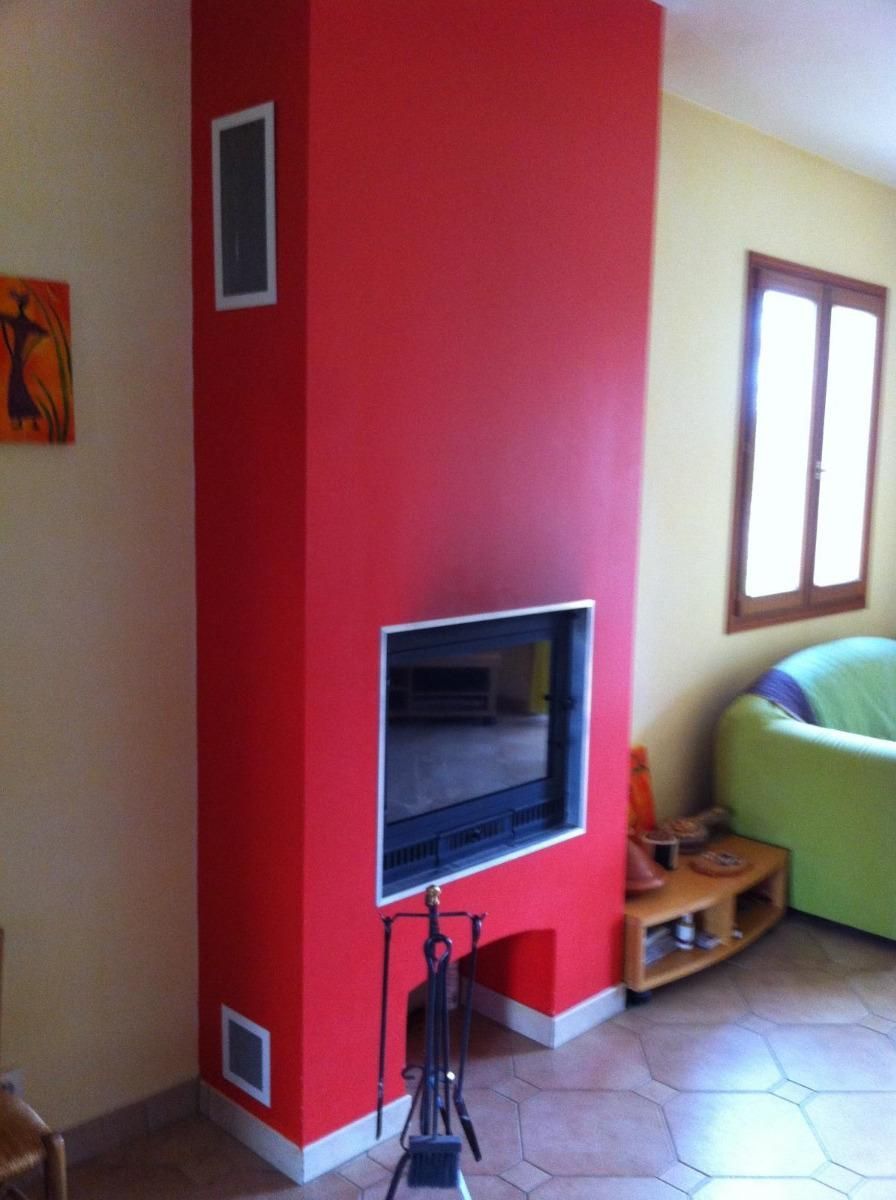 Cheminée encastrée dans un mur rouge