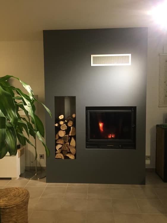Installation d'une cheminée encastrée dans un mur gris