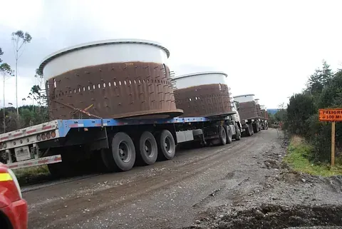 Una fila de camiones circula por un camino de tierra