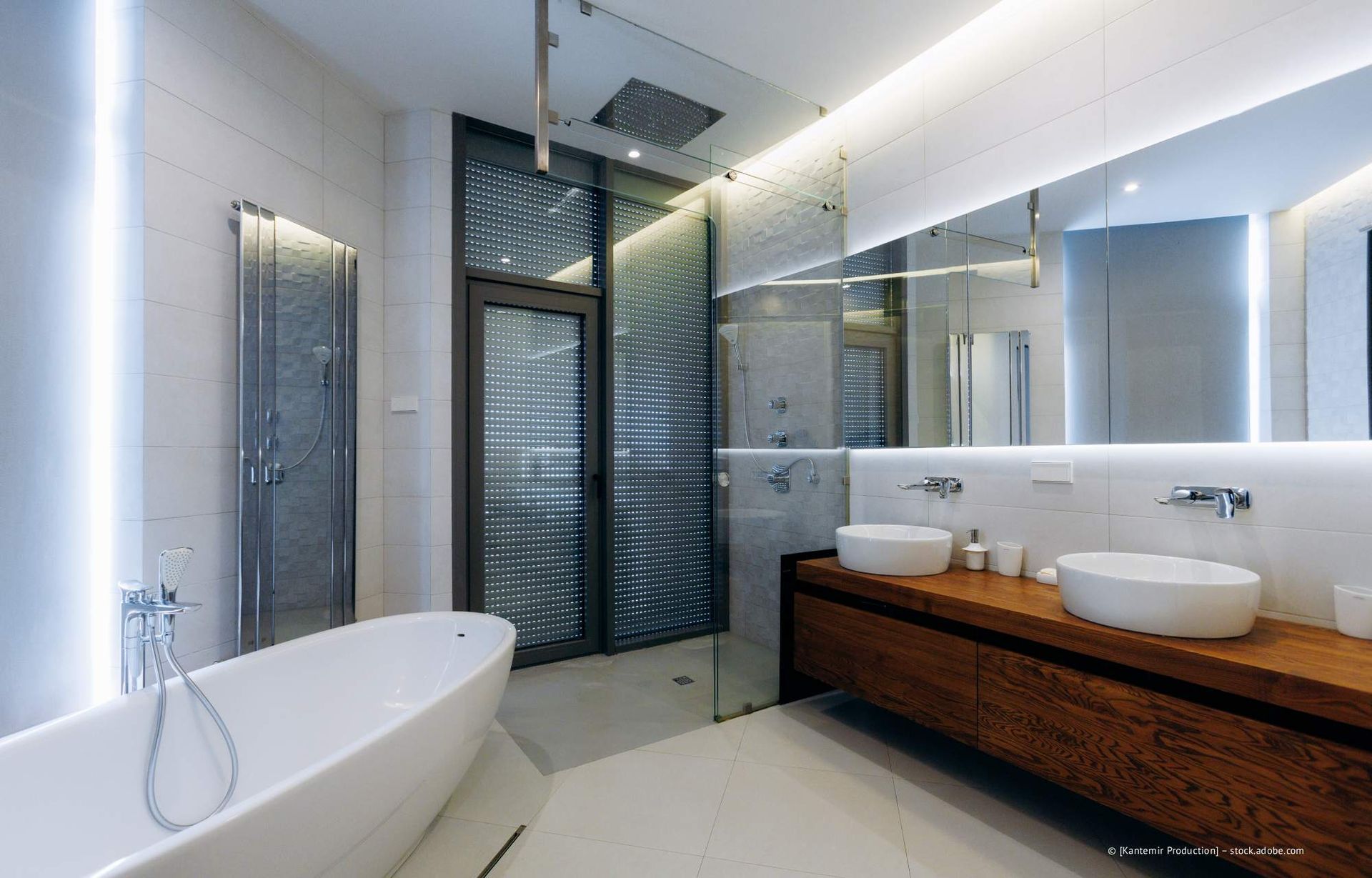Modernes Badezimmer mit weißer Badewanne, Doppelwaschbecken und verglaster Dusche.